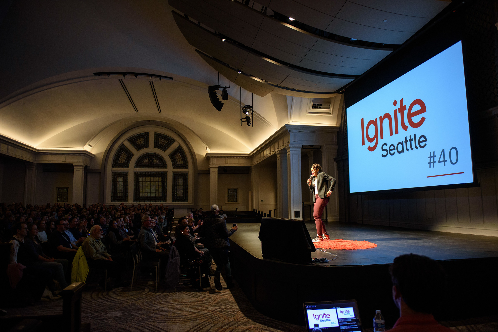 Speaker on stage at Ignite Seattle with the Ignite Seattle screen behind her.