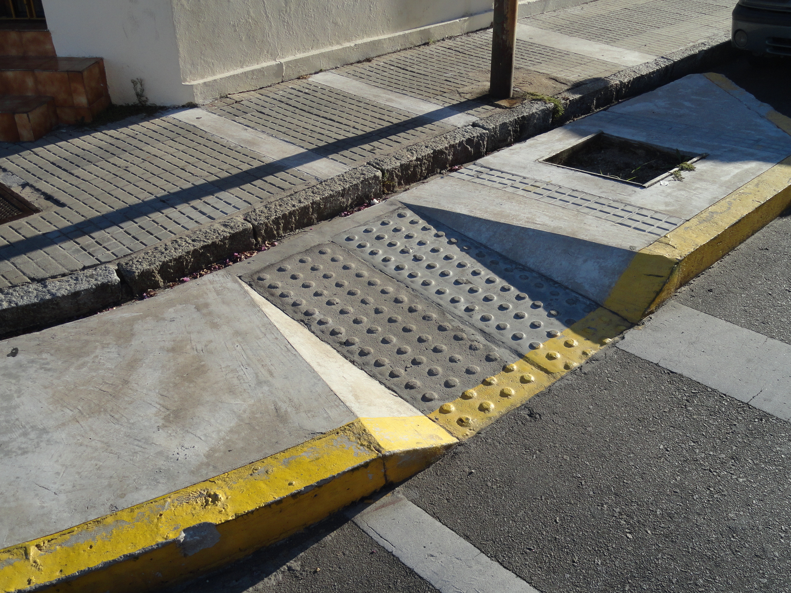 The 15-Minute City Has an Imaginary Resident A pedestrian access ramp ends at a drainage opening in Maldonado, Uruguay, creating an impassable transition for some wheelchair users.