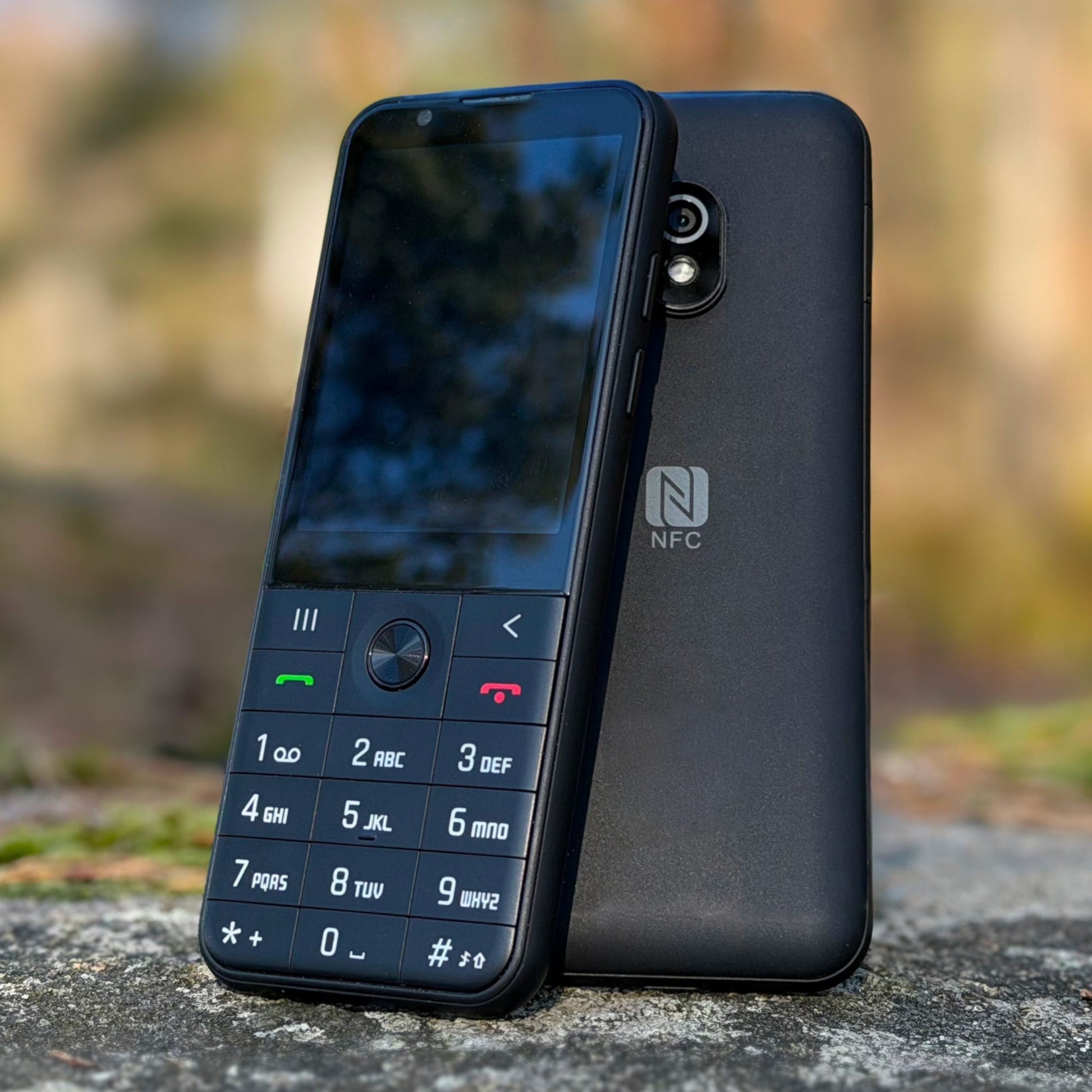 Best Dumb Phones in 2026: The Minimalist Phones That Actually Make Sense Dumber Mini keypad phone shown from the front and back outdoors.